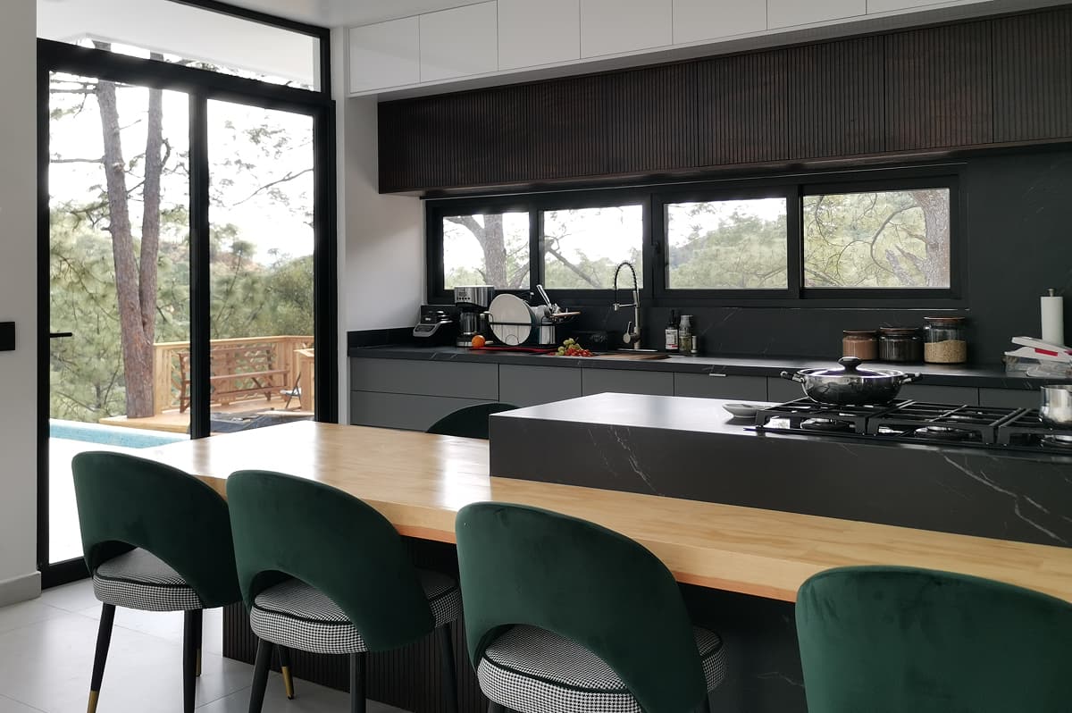 Cocina con isla en Surutato: diseño moderno con barra de madera y cubierta negra